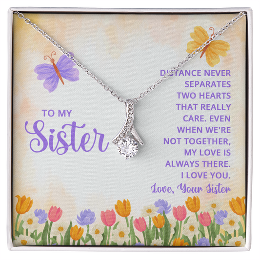 Alluring Beauty necklace for a sister with a message card that reads "Distance never separates two hearts that really care" and a floral butterfly design