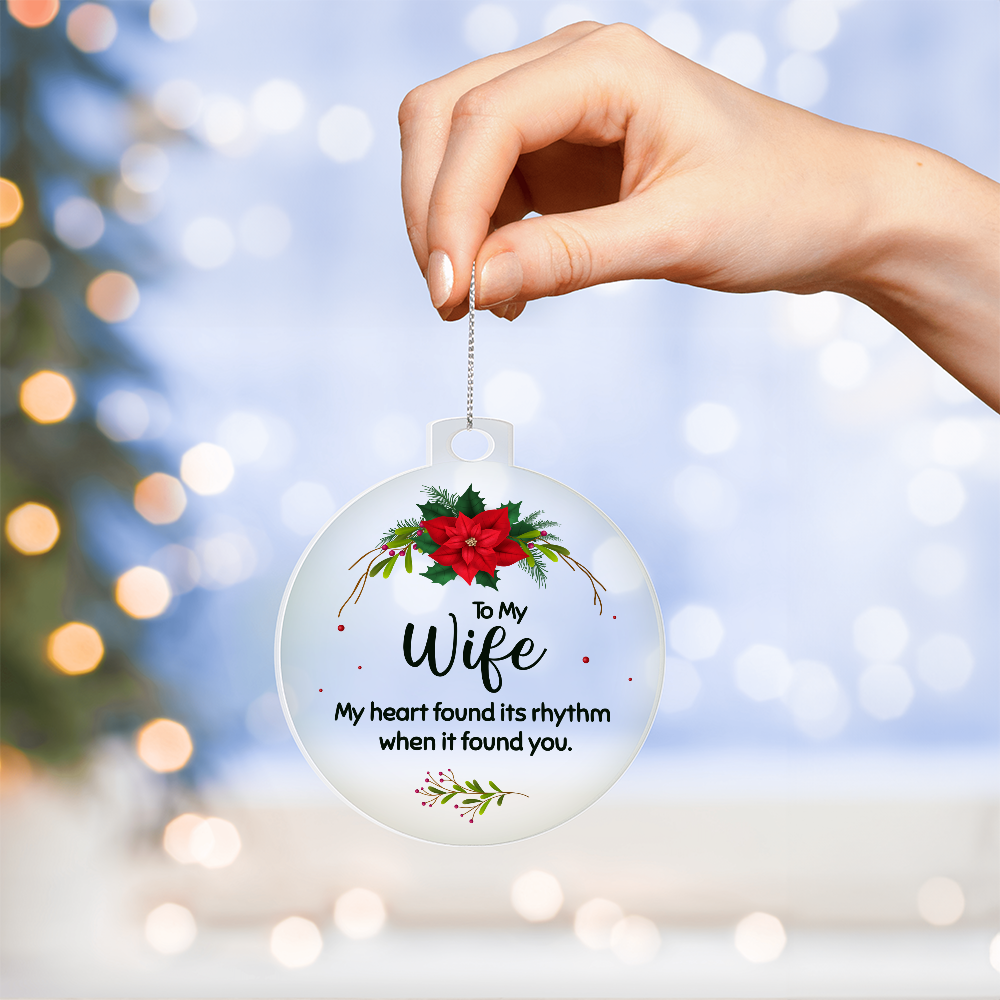 White round Christmas ornament for a wife with a poinsettia and the romantic quote 'My heart found its rhythm when it found you.'